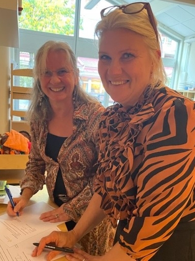 2 kvinnor tittar leende in i kameran